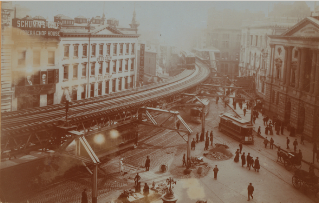 This 1900 photograph of Fulton Street at the intersection of Joralemon Street and Boreum Place shows a trolley car rolling underneath the Fulton Street elevated train tracks. The cat in this story became trapped between the elevated tracks and the wires connecting to the trolley cars. New York Public Library Digital Collections