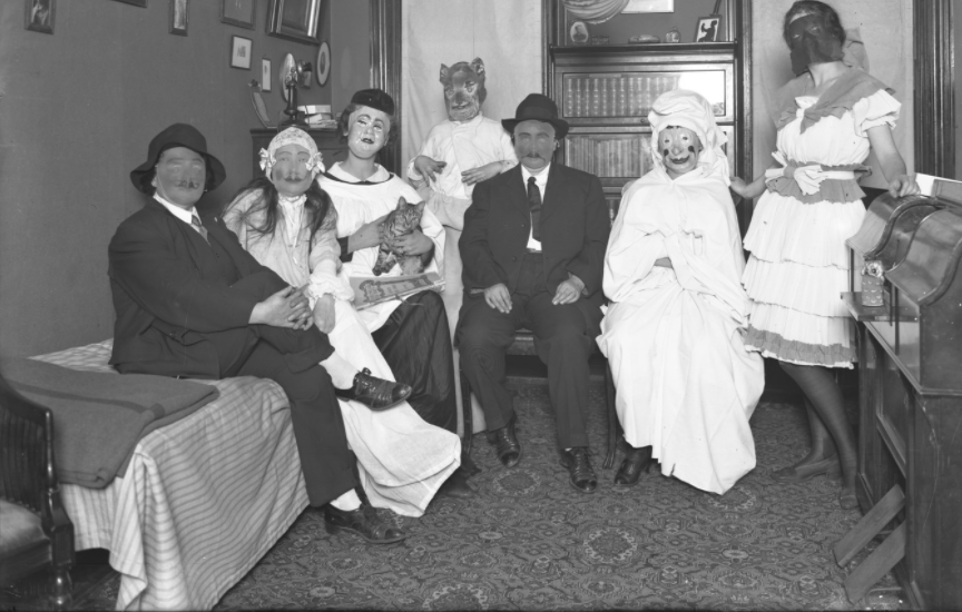 Unidentified group of people in Halloween costumes with an unidentified cat at the Hassler's apartment on October 31, 1916. Photographed for Mrs. Reiser.
