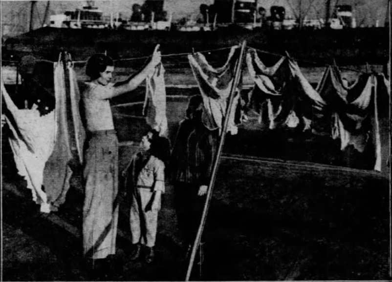Mrs. George Leonard hangs the wash in a barge colony at Gowanus Bay, Brooklyn, 1939.
